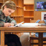 Persona tachando hábitos cumplidos en un calendario de pared