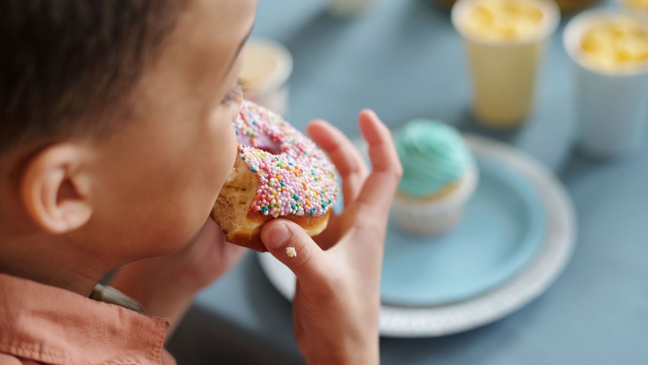 Niño concentrado comiendo alimentos nutritivos para el TDAH