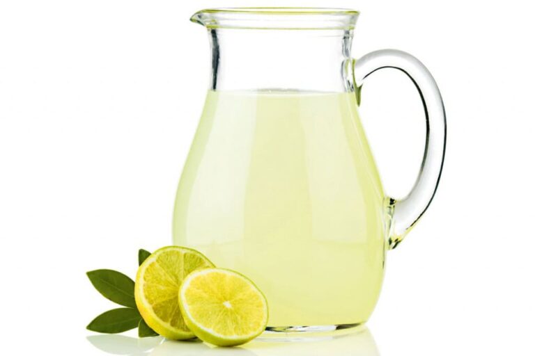 Vaso con suero casero natural junto a ingredientes frescos como limón, sal y miel